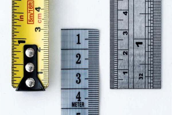 High-resolution image of a tape measure and rulers, showing precise millimeter, centimeter, and inch markings.