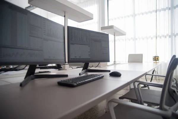 Stylish contemporary office featuring multiple computer monitors and ergonomic chairs.