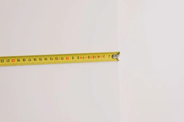 Yellow measuring tape on white wall in room at home during renovation works